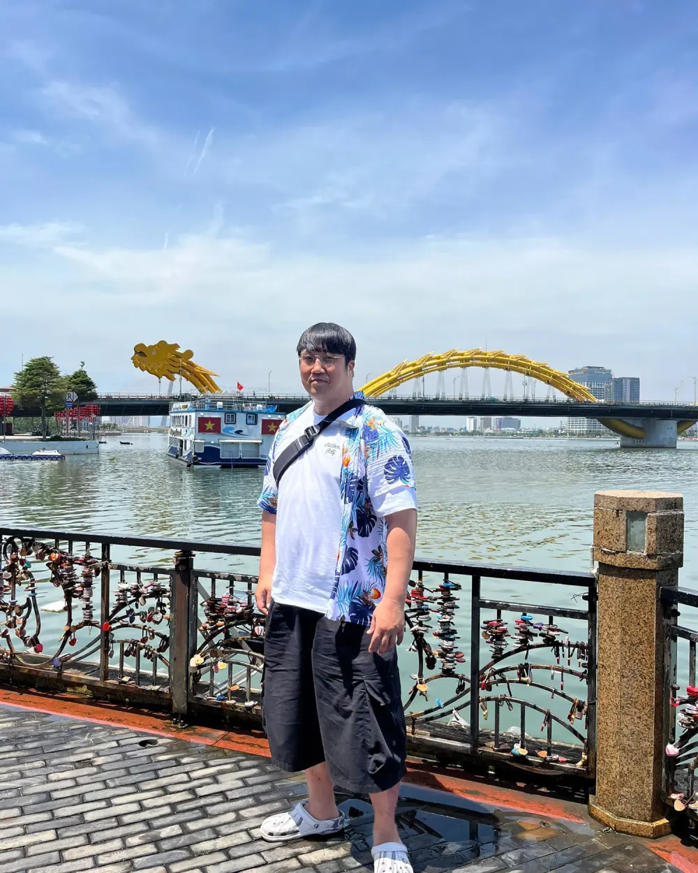 A guest on the Han River promenade with the Dragon Bridge behind, Da Nang