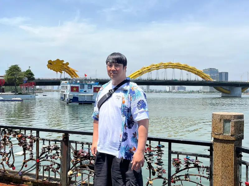 A guest on the Han River promenade with the Dragon Bridge behind, Da Nang