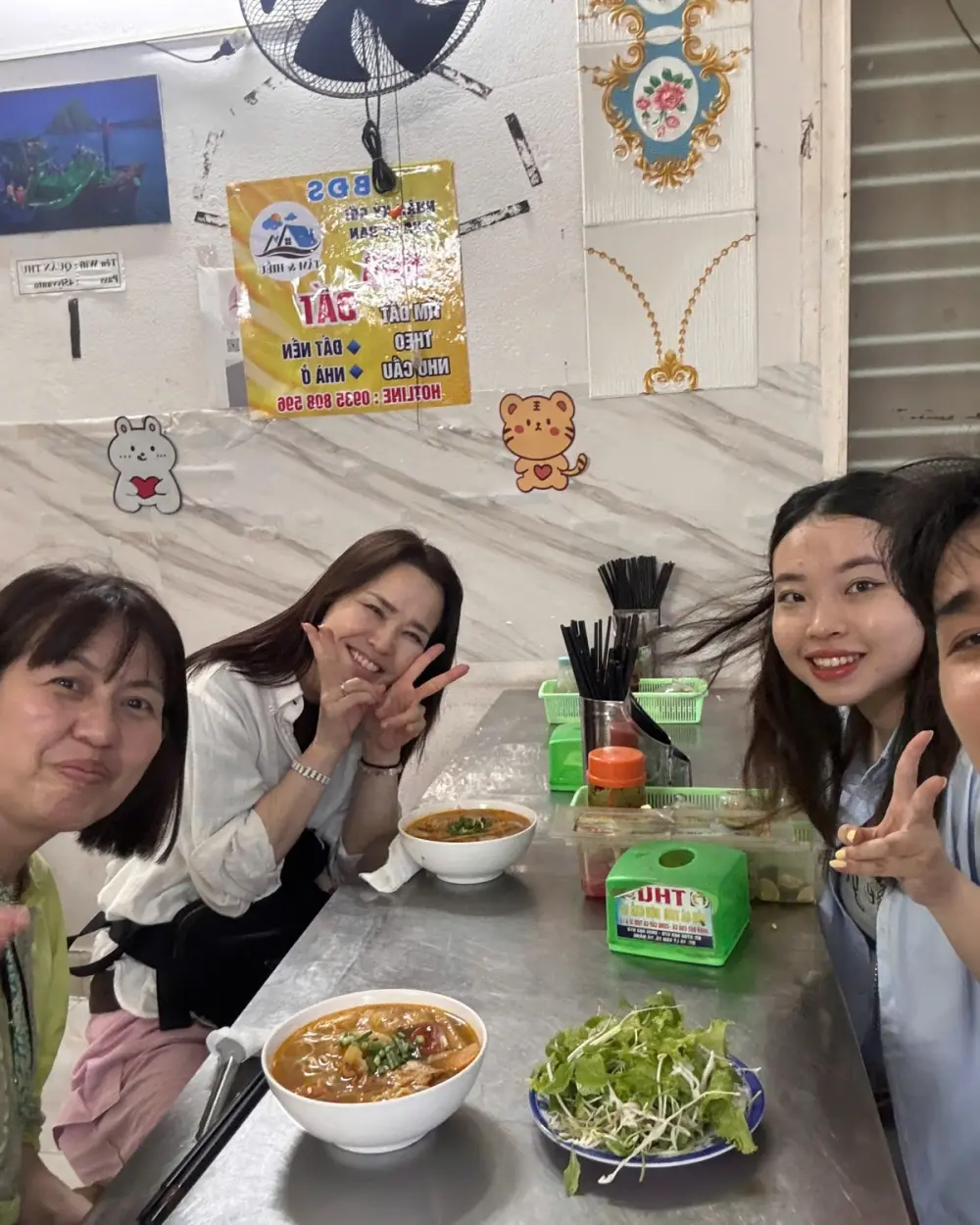 Guests with a bowl of mì Quảng and fresh herbs
