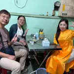 An áo dài rider with her guests at a local eatery in Saigon