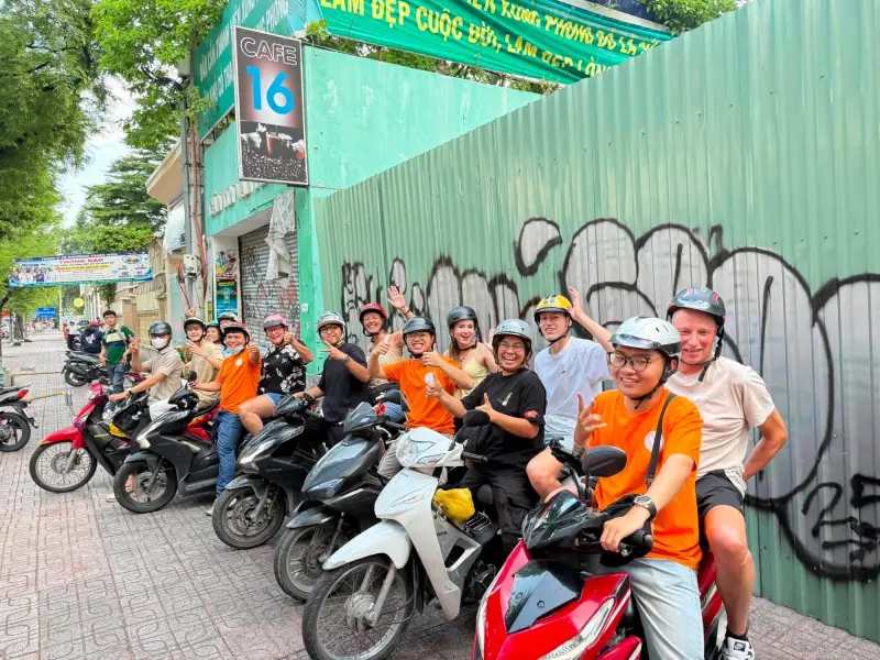 Guests and local riders lined up on motorbikes before a Saigon food tour
