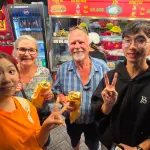 Guests holding fresh bánh mì at a Saigon bánh mì stall