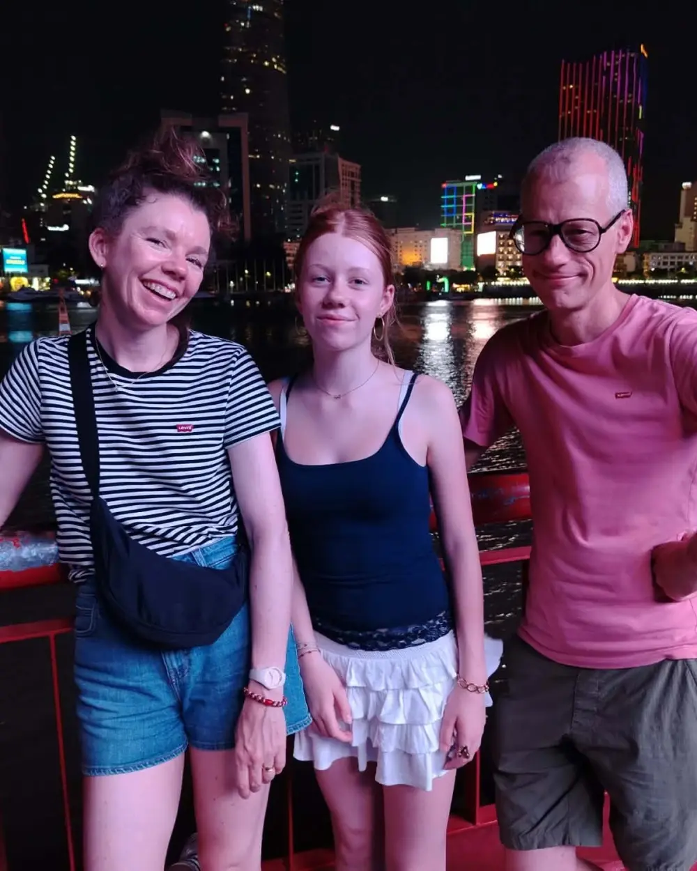 Guests on the Saigon riverside with the city lights behind
