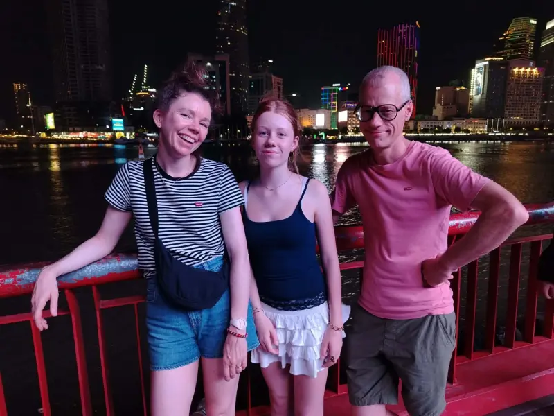 Guests on the Saigon riverside with the city lights behind